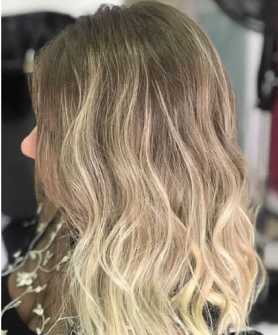Cabelo loiro com raiz esfumada e ondas suaves visto de lado
