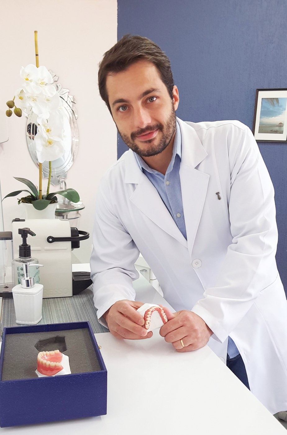 Dr. Gabriel Rinaldi, de jaleco, no consultório da clínica